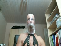Fetish friendly male cam model dressed in black lingerie traps scat in his mouth with saran-wrap